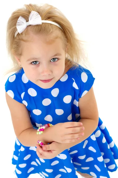 Uma menina coloca uma pulseira em seu braço . — Fotografia de Stock