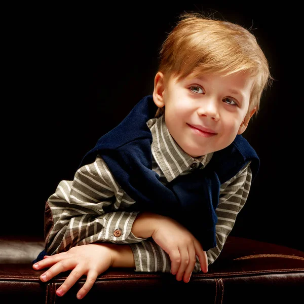 Krásný malý chlapec na černém pozadí, close-up. — Stock fotografie