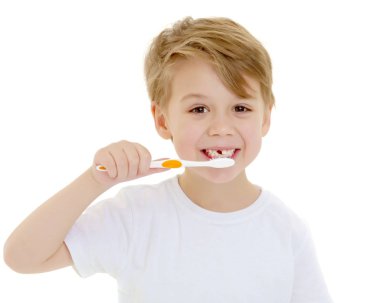 Küçük bir çocuk diş fırçasıyla dişlerini fırçalıyor..