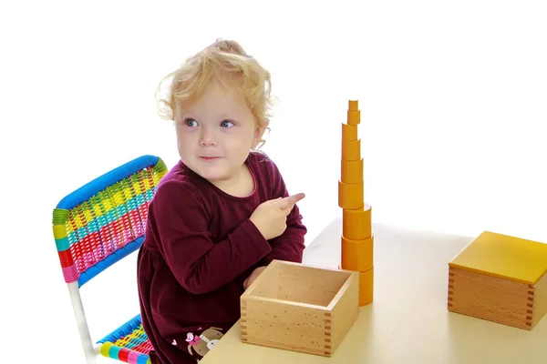 La petite fille à la table travaille avec le matériau Montessori . — Photo