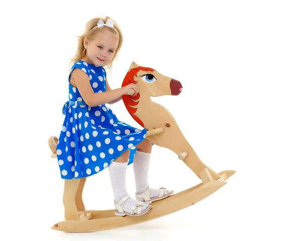 Chica balanceándose en un caballo de madera . —  Fotos de Stock