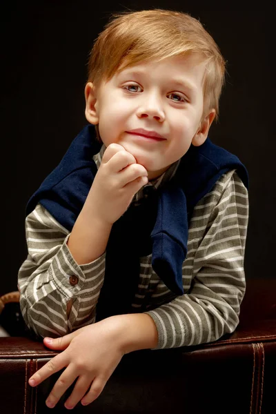 Beautiful little boy on a black background, close-up. Stock Photo