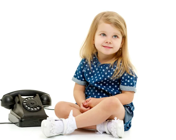 Ένα κοριτσάκι χτυπάει στο παλιό τηλέφωνο.. — Φωτογραφία Αρχείου