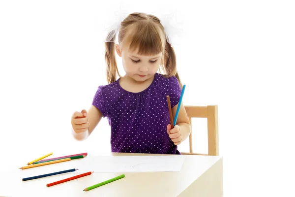 Uma menina está desenhando na mesa . — Fotografia de Stock