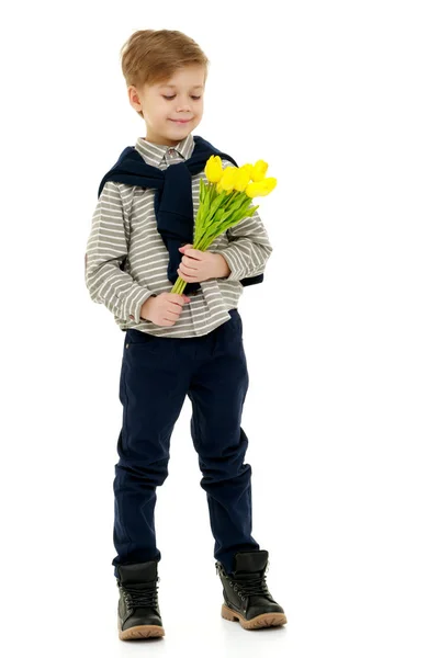 Liten pojke med en bukett blommor tulpaner. — Stockfoto