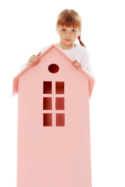 Little girl is playing with wooden houses. — Stock Photo, Image