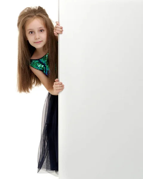 Ein kleines Mädchen blickt hinter einem leeren Banner hervor. — Stockfoto