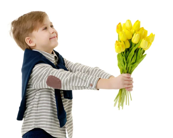 Petit garçon avec un bouquet de fleurs tulipes . — Photo