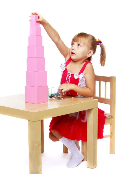 Uma menina em Montessori no jardim de infância está brincando com um pi — Fotografia de Stock