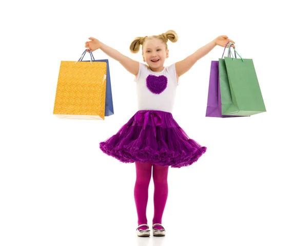 Niña con bolsas multicolores en sus manos. —  Fotos de Stock