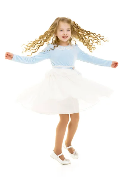 Uma menina em um vestido está girando . — Fotografia de Stock