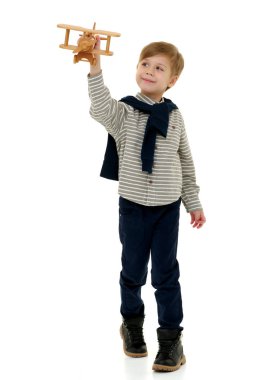Küçük çocuk tahta uçakla oynuyor.