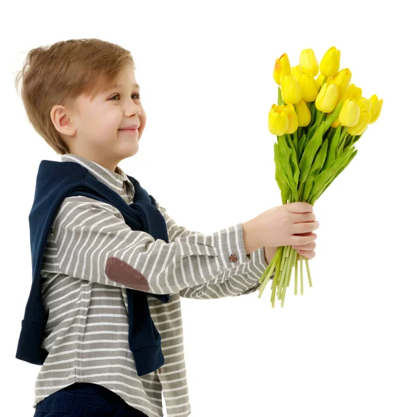 Kleiner Junge mit einem Strauß Tulpen. — Stockfoto