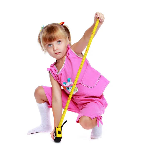 Little girl with a building tape measure. — Stock Photo, Image