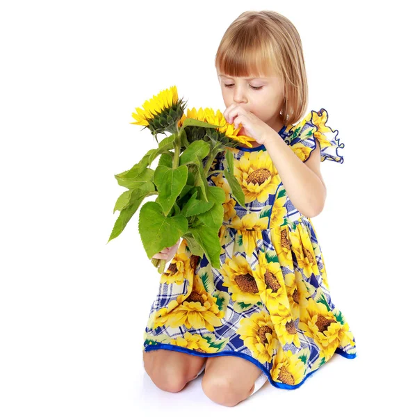 Klein meisje met bloemen van zonnebloem. — Stockfoto