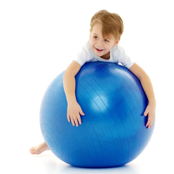 Büyük topu üzerinde küçük çocuk fitness devreye girer. Beyaz T-sh — Stok fotoğraf