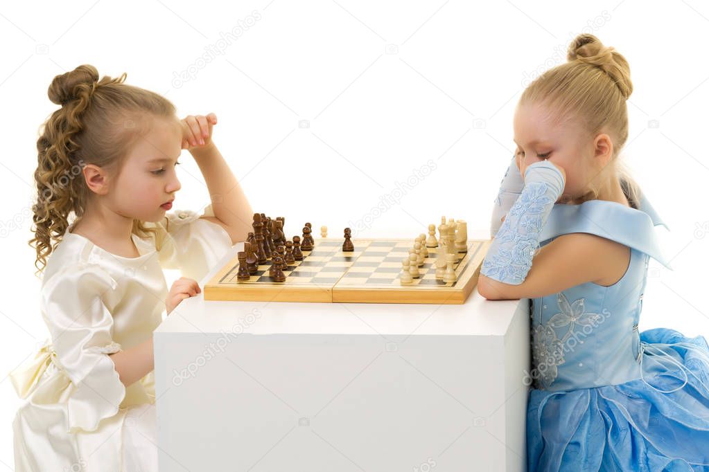 Little girls play chess.