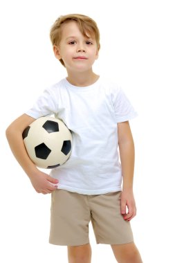 Saf beyaz giyen küçük bir çocuk t-shirt ile bir socc oynuyor