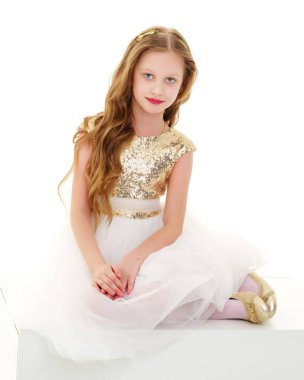 Küçük kız beyaz bir pankartta oturuyor..