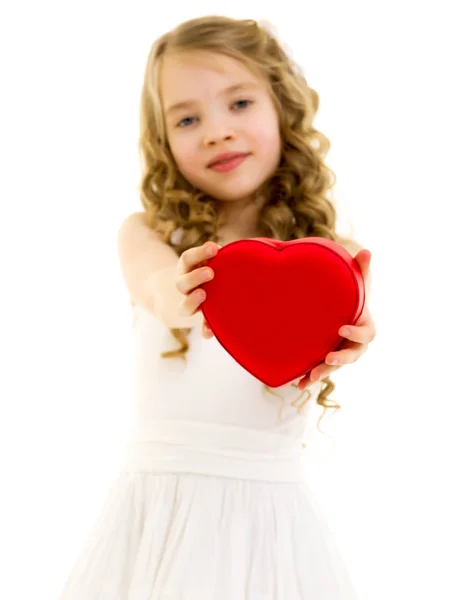 Ein kleines Mädchen hält ein Herz. — Stockfoto