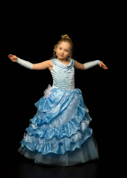 Uma menina em um vestido longo e elegante de uma princesa em um preto — Fotografia de Stock