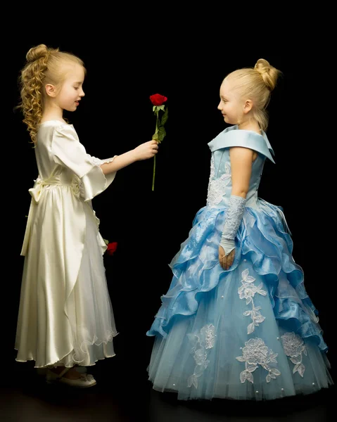 两个公主女孩与鲜花在黑色背景. — 图库照片