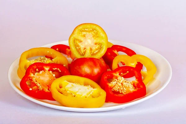 Poivron tranché rouge et jaune gît sur l'assiette . — Photo