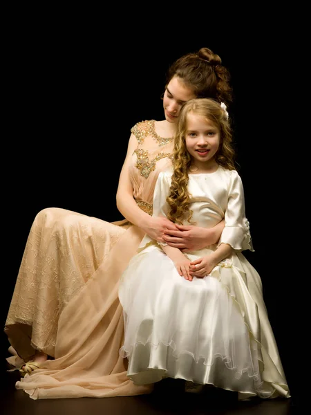 Ein junges Mädchen umarmt ihre kleine Schwester. — Stockfoto