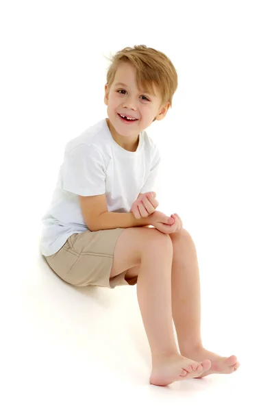 一个穿着纯白T恤的小男孩笑了。感情. — 图库照片
