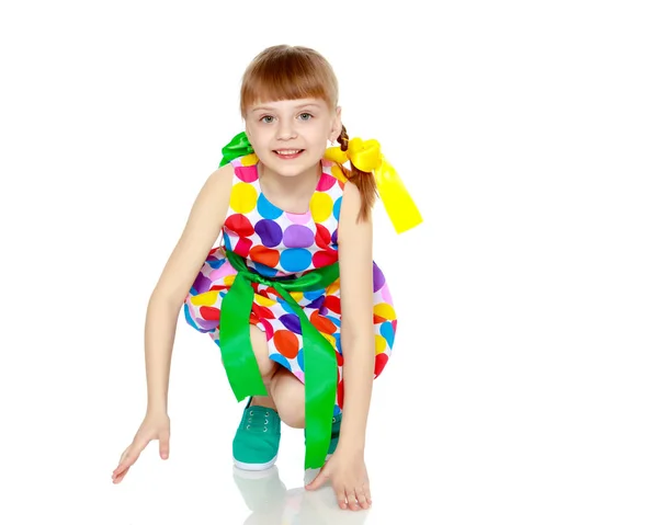 Una niña en un vestido con un patrón de circl multicolor — Foto de Stock