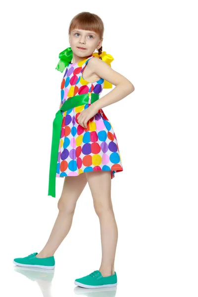 A little girl in a dress with a pattern from multi-colored circl — Stock Photo, Image