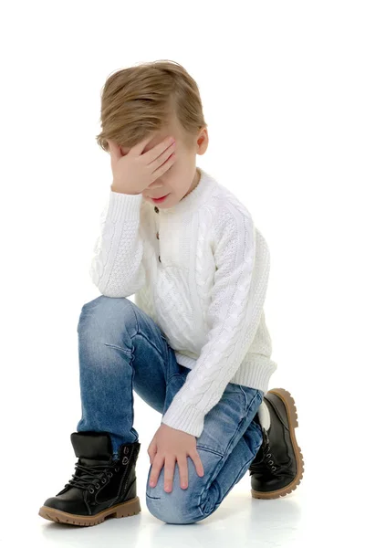 Un niño pequeño toca su frente . —  Fotos de Stock