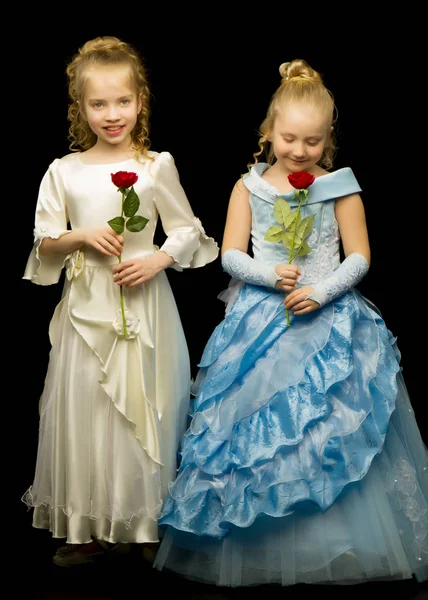 Två prinsessan flickor med blommor på en svart bakgrund. — Stockfoto
