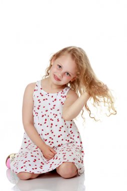 Küçük kız yerde oturuyor..