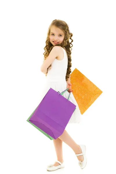 Niña con bolsas multicolores en sus manos. —  Fotos de Stock