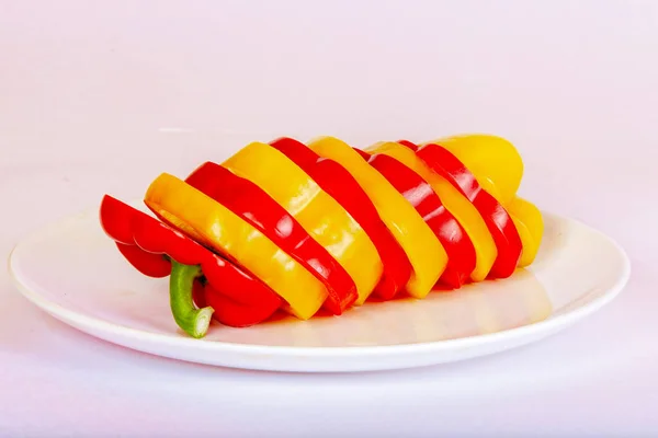 A tányéron a szeletelt paprika piros és sárga. — Stock Fotó