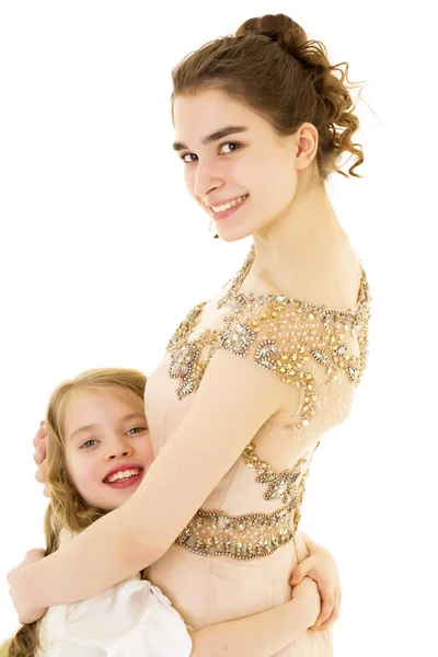 Ein junges Mädchen umarmt ihre kleine Schwester. — Stockfoto