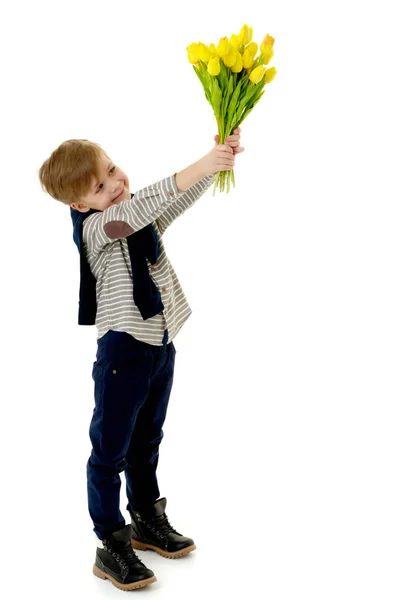 Petit garçon avec un bouquet de fleurs tulipes . — Photo