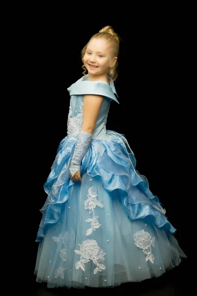 Ein kleines Mädchen in einem langen, eleganten Kleid einer Prinzessin auf einem schwarzen — Stockfoto