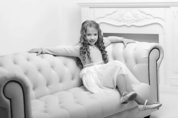 Little girl is sitting on the couch — Stock Photo, Image