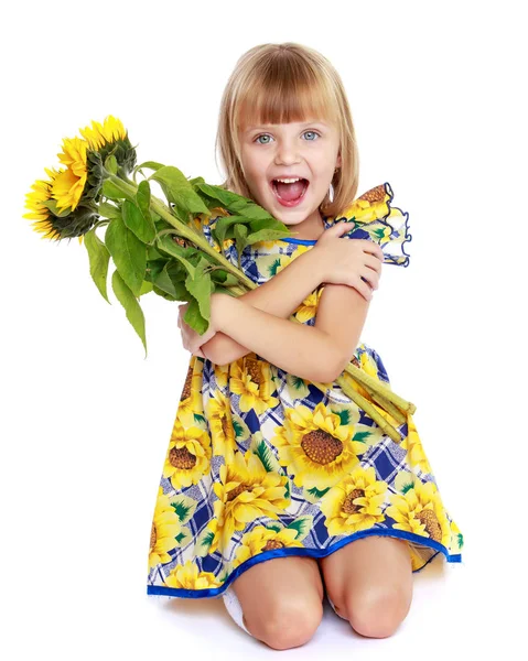 Klein meisje met bloemen van zonnebloem. — Stockfoto