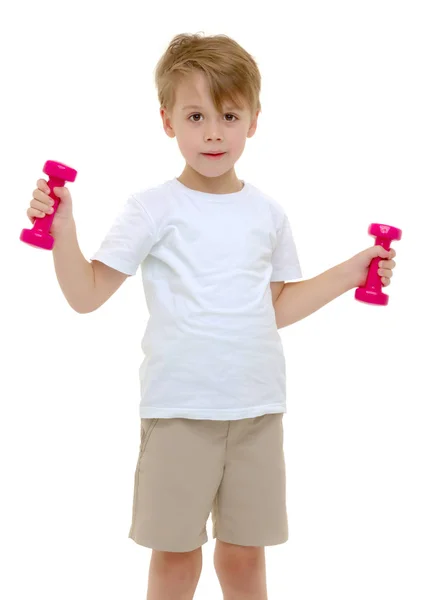 Um menino está levantando halteres . — Fotografia de Stock