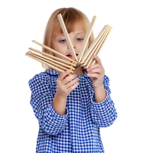 Una niña pequeña toca un sonajero . — Foto de Stock