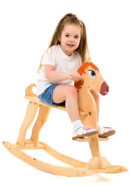 Девушка, качающаяся на деревянной лошади . — стоковое фото