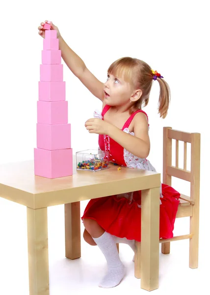 Una niña en Montessori en el jardín de infantes está jugando con un pi — Foto de Stock