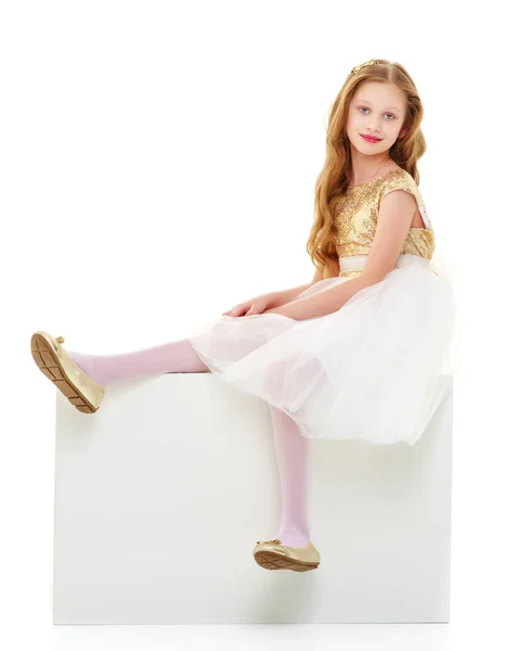 Het kleine meisje zit op een wit spandoek.. — Stockfoto