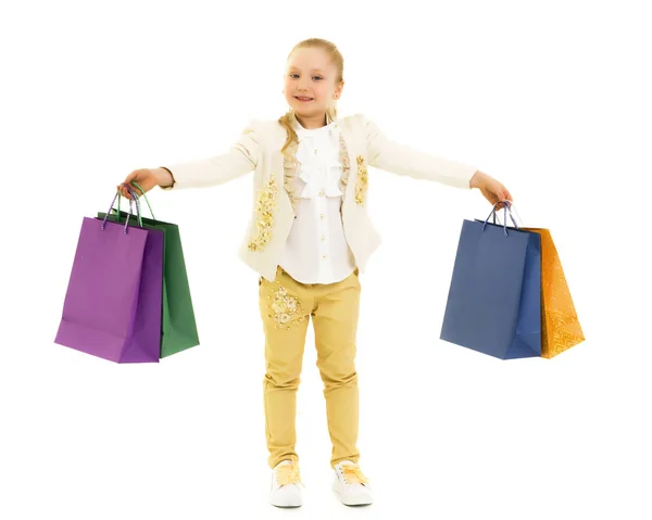 Menina com sacos multicoloridos em suas mãos. — Fotografia de Stock