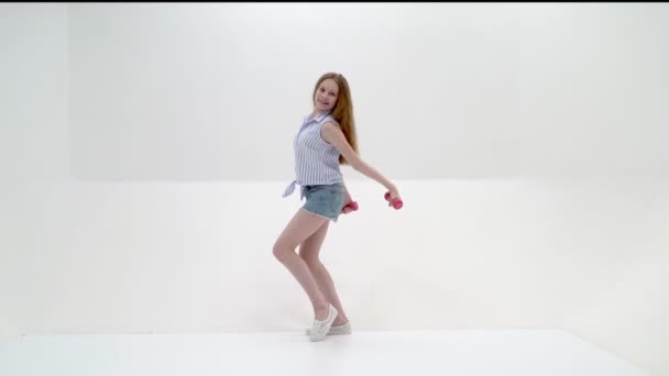 Девочка-подросток с гантелями в руках — стоковое видео