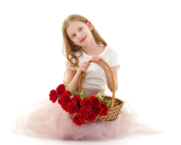 Niedliches kleines Mädchen mit einem Korb voller Blumen. — Stockfoto