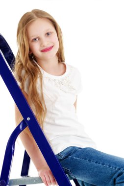 Küçük bir kız merdivene tırmanıyor.